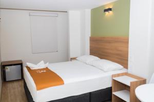 een kleine kamer met een bed en een wastafel bij Zentra Hotel in Chiclayo