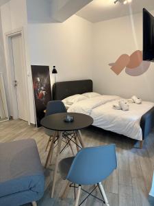um quarto com uma cama, uma mesa e cadeiras em Brand new studios IPM1-2-3-4 em Lárissa
