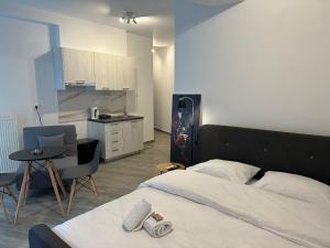 a bedroom with a bed and a table and a kitchen at Brand new studios IPM1-2-3-4 in Larisa