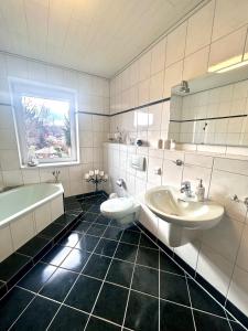 La salle de bains est pourvue d'un lavabo, d'une baignoire et de toilettes. dans l'établissement Ferienwohnung TINA, à Naumbourg