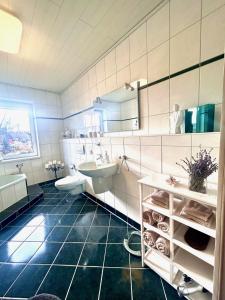 La salle de bains est pourvue d'un lavabo, de toilettes et d'une baignoire. dans l'établissement Ferienwohnung TINA, à Naumbourg