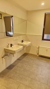 La salle de bains est pourvue de 2 lavabos et d'un miroir. dans l'établissement Gästezimmer, à Mönchengladbach