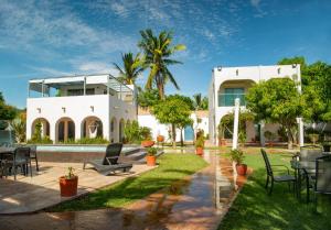 a large white house with chairs and tables in a yard at FINCA LUZ DEL MAR in Topolobampo