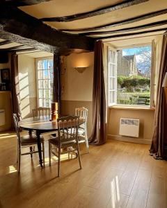 d'une salle à manger avec une table, des chaises et une fenêtre. dans l'établissement Manoir de la Bégaudière, à Mont-Dol