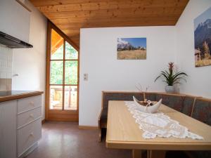 una cucina e una sala da pranzo con tavolo in legno di Appartements Michael a Sesto