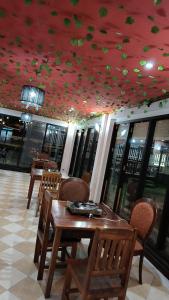 a restaurant with a table and chairs and a red ceiling at ShuYa Hotel 舒雅酒店 in Luang Prabang