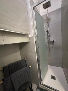 a shower with a glass door next to a chair at ROMA HOME in Udine