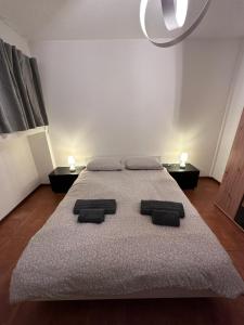 a bedroom with a large bed with two lights on it at ROMA HOME in Udine