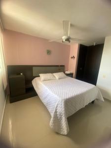 1 dormitorio con cama blanca y techo en Apartamento norte Barranquilla 2 habitaciones en Barranquilla