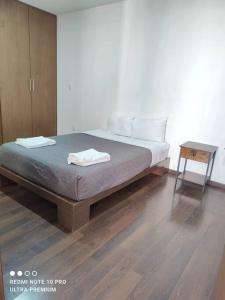 Departamento nuevo en la Paz, Puebla ROSS في Momoxpan: غرفة نوم بسرير وارضية خشبية