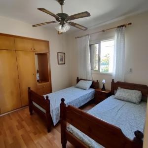een slaapkamer met 2 bedden en een plafondventilator bij Quiet holiday house near the beach in Menevi