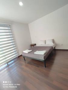 Departamento nuevo en la Paz, Puebla ROSS في Momoxpan: غرفة نوم مع سرير في غرفة مع نافذة