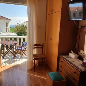 een kamer met een balkon met een tafel en stoelen bij Quiet holiday house near the beach in Menevi