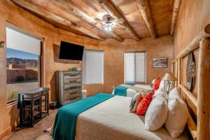 a bedroom with two beds and a flat screen tv at Zion White Bison Glamping & RV Resort in Virgin