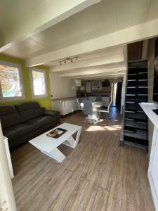ein Wohnzimmer mit einem Sofa und einem Tisch in der Unterkunft Le bruit des vagues en dormant in Sausset-les-Pins