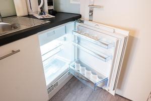 an empty refrigerator with its door open in a kitchen at Urban Oasis with Queen Bed and View BE-13 in Zürich