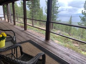 a porch with two chairs and a table and a view of the water at Tahoe Lake View Hill Top Retreat in Incline Village