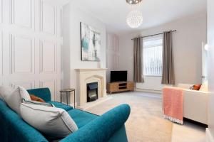 a living room with a blue couch and a fireplace at Urban Chic in Hartlepool