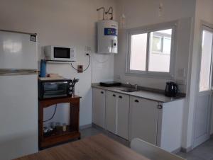 a kitchen with a refrigerator and a microwave at El Balconcito Dos ambientes in Saladillo
