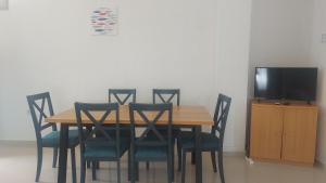 a dining room table with chairs and a television at Apartments Punta Kanica in Sevid