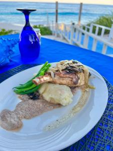 une assiette de nourriture sur une table avec la plage dans l'établissement Exuma Palms Resort, à Hermitage