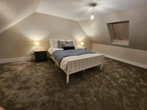 een slaapkamer met een bed en twee nachtkastjes en twee lampen bij HollyJess Hoose in Stranraer