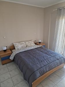 ein Schlafzimmer mit einem großen Bett mit zwei Nachttischen in der Unterkunft Zorzet in Kardítsa