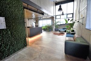 eine Bürolobby mit einer grünen Wand und einem Sofa in der Unterkunft Jasminn Apartments in Prag