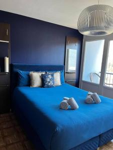 um quarto azul com uma cama azul com toalhas em Appartement 4 couchages centre-ville em Albertville