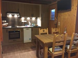 a kitchen with a wooden table and a table and chairs at Chalet dans clairiere in Bolquere Pyrenees 2000