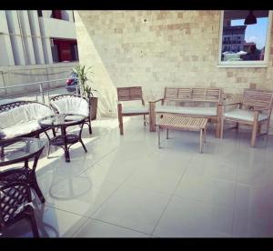 um pátio com mesas e cadeiras, uma mesa e bancos em Abi Mykonos em Mamaia Nord – Năvodari