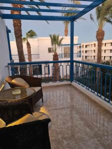 a balcony with a table and chairs and palm trees at شاليه مميز جدا فندق ميراج شاطئ كبير in Hurghada
