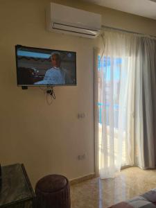 a tv hanging on a wall in a living room at شاليه مميز جدا فندق ميراج شاطئ كبير in Hurghada