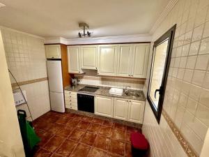 eine Küche mit weißen Schränken und Fliesenboden in der Unterkunft Sol & Mar in El Médano