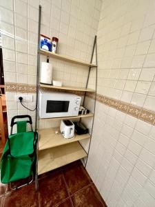 a small kitchen with a microwave on a shelf at Sol & Mar in El Médano
