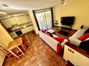 ein Wohnzimmer mit einem Sofa und einem TV in der Unterkunft Sol & Mar in El Médano