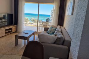 a living room with a couch and a view of the ocean at Stunning sea vistas by the beach in Benicàssim