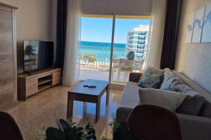 a living room with a couch and a view of the ocean at Stunning sea vistas by the beach in Benicàssim