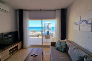 ein Wohnzimmer mit einem Sofa und Meerblick in der Unterkunft Stunning sea vistas by the beach in Benicàssim