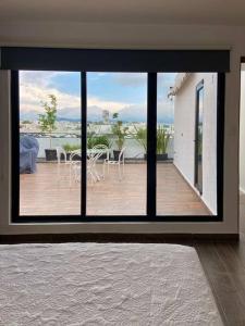 a room with a view of a patio with tables and chairs at Departamento en lomas de angelopolis, Isla blanca in Lomas de Angelopolis