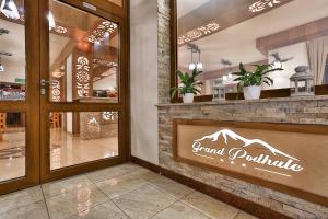 a store front with a mountain sign on the window at Grand Podhale Resort&Spa Zakopane - Jacuzzi z możliwością rezerwacji na wyłączność - Widok na Tatry in Zakopane