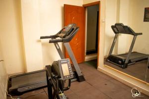 um ginásio com duas máquinas de piso e um espelho em The Unit em Nyeri