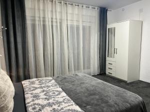 um quarto com uma cama e uma cómoda e cortinas em LuxRooms BJELOVAR em Bjelovar