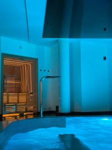 Westin House Resort&Spa Kołobrzeg في كولوبرزيغ: غرفة زرقاء مع حوض سباحة