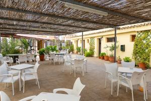 une terrasse avec des tables et des chaises blanches dans l'établissement VER3 - Piscinas - Fire Stick TV - 10 min Playa -Reformado, à Torremolinos