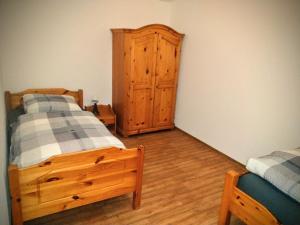 a bedroom with two beds and a wooden cabinet at Ferienhof Nustede in Wardenburg