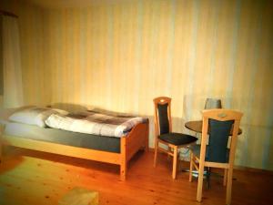 1 Schlafzimmer mit einem Bett, 2 Stühlen und einem Tisch in der Unterkunft Ferienhof Nustede in Wardenburg