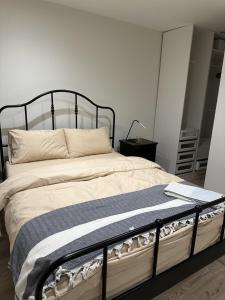 a bedroom with a bed with a black frame at Brand new suit room 10 min to walk central line! in Woodford