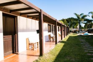 a porch of a house with a wooden pergola at La Quinta Hostel & Suites in Punta del Este