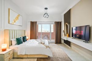 Luxurious Apt Near Jbr في دبي: غرفة نوم بسرير وتلفزيون بشاشة مسطحة